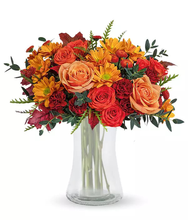 Rustic sunset bouquet of orange roses in glass vase